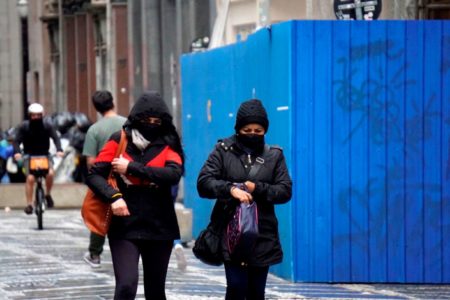 Imagem colorida de pessoas agasalhadas virada no tempo - Metrópoles
