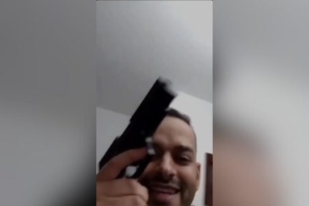 Imagem colorida traz frame de vídeo com Felipe Lima segurando uma arma - Metrópoles
