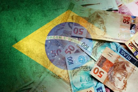 Imagem ilustrativa de bandeira do Brasil e cédulas do real - Metrópoles