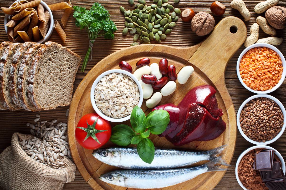 Foto colorida de alimentos em cima de uma mesa e de uma tábua, como peixes, grãos, vegetais, chocolate, pães e carnes - Metrópoles