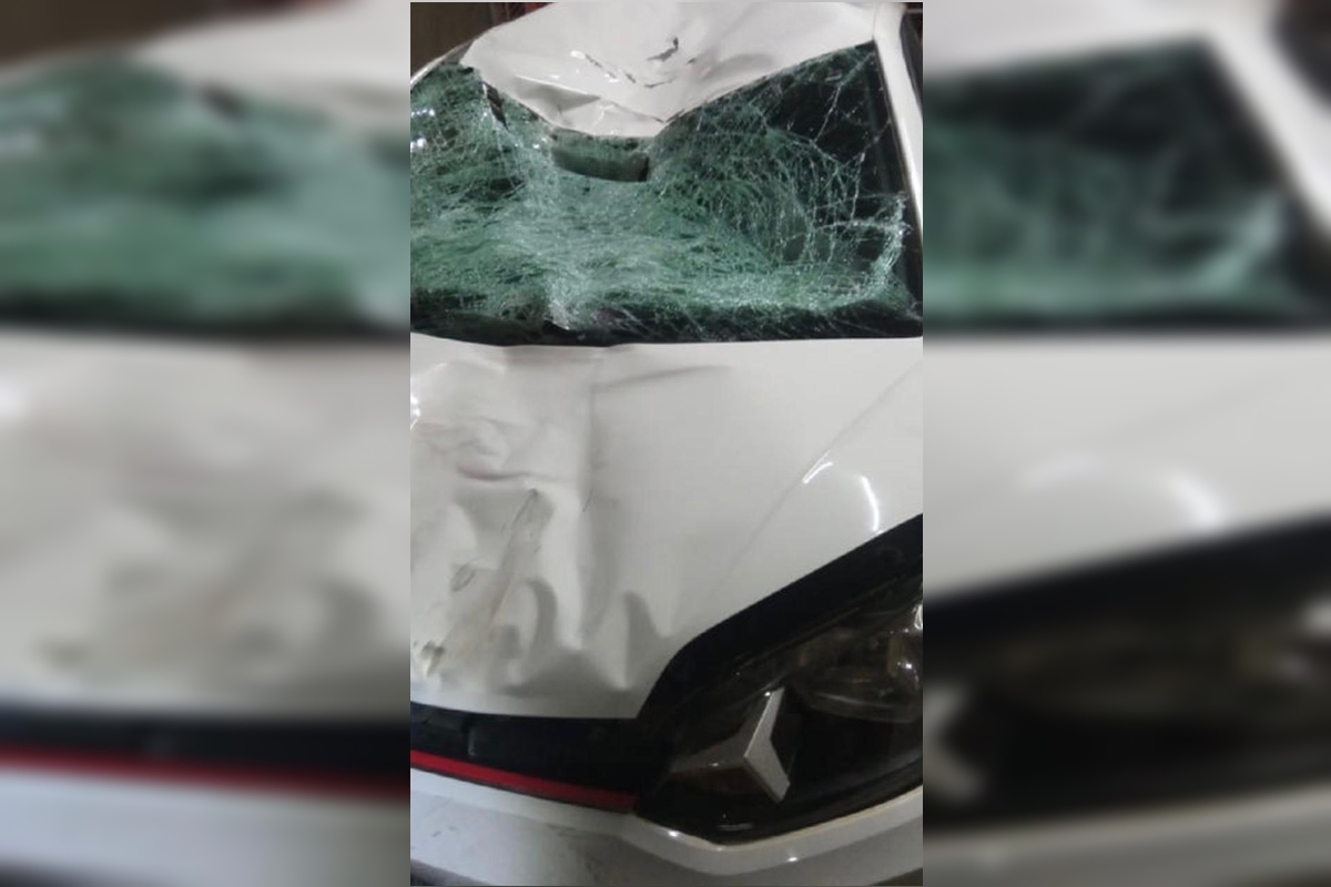 Imagem colorida de um carro branco com marcas de colisão no para-brisa