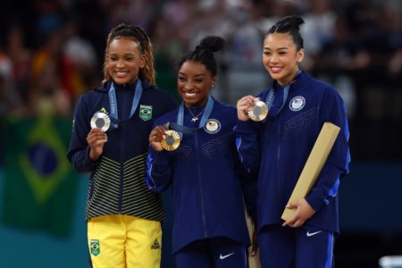 Imagem colorida do pódio com Simone Biles, Rebeca Andrade e Sunisa Lee | Metrópoles