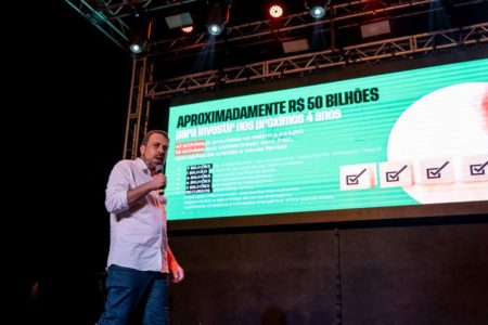 Guilherme Boulos apresenta, em slides em um telão, seu plano de governo à Prefeitura de SP - Metrópoles