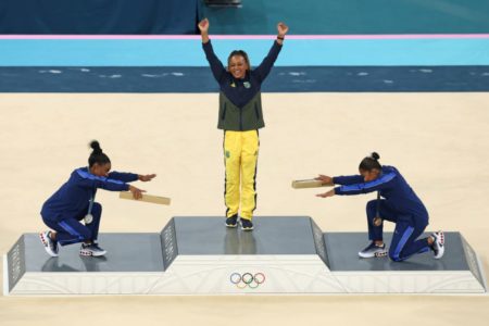 Imagem colorida de Rebeca Andrade, reverenciada por Simone Biles no pódio das Olimpíadas- Metrópoles