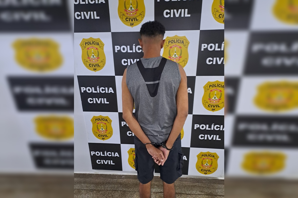 Imagem colorida de homem com camiseta cinza de costas e algemado
