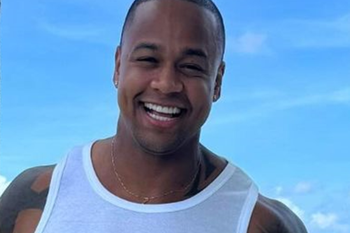 Léo Santana posa, sorridente, de camiseta branca - Metrópoles