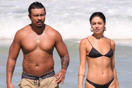 Na imagem colorida, Sophie Charlotte e Xamã aparecem em praia. Ela usa biquíni preto, e o cantor surge de bermuda bege - Metrópoles