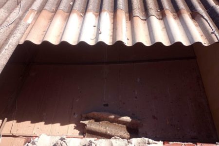 Foto colorida de telhado de telhas quebrado