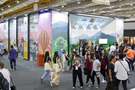 Imagem colorida mostra pessoas caminhando em pavilhão da Bienal do Livro de SP