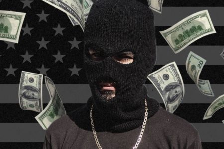 Imagem colorida mostra homem encapuçado com notas de dinheiro voando ao fundo - Metrópoles