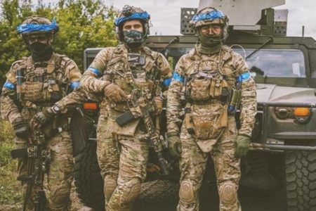 Imagem colorida mostra três homens vestidos com roupas militares - Metrópoles