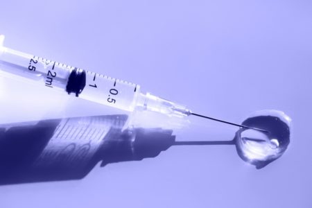 Vacina em fundo roxo, com gora na agulha - Metrópoles
