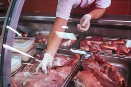 Imagem colorida de pessoa segurando carnes - Metrópoles