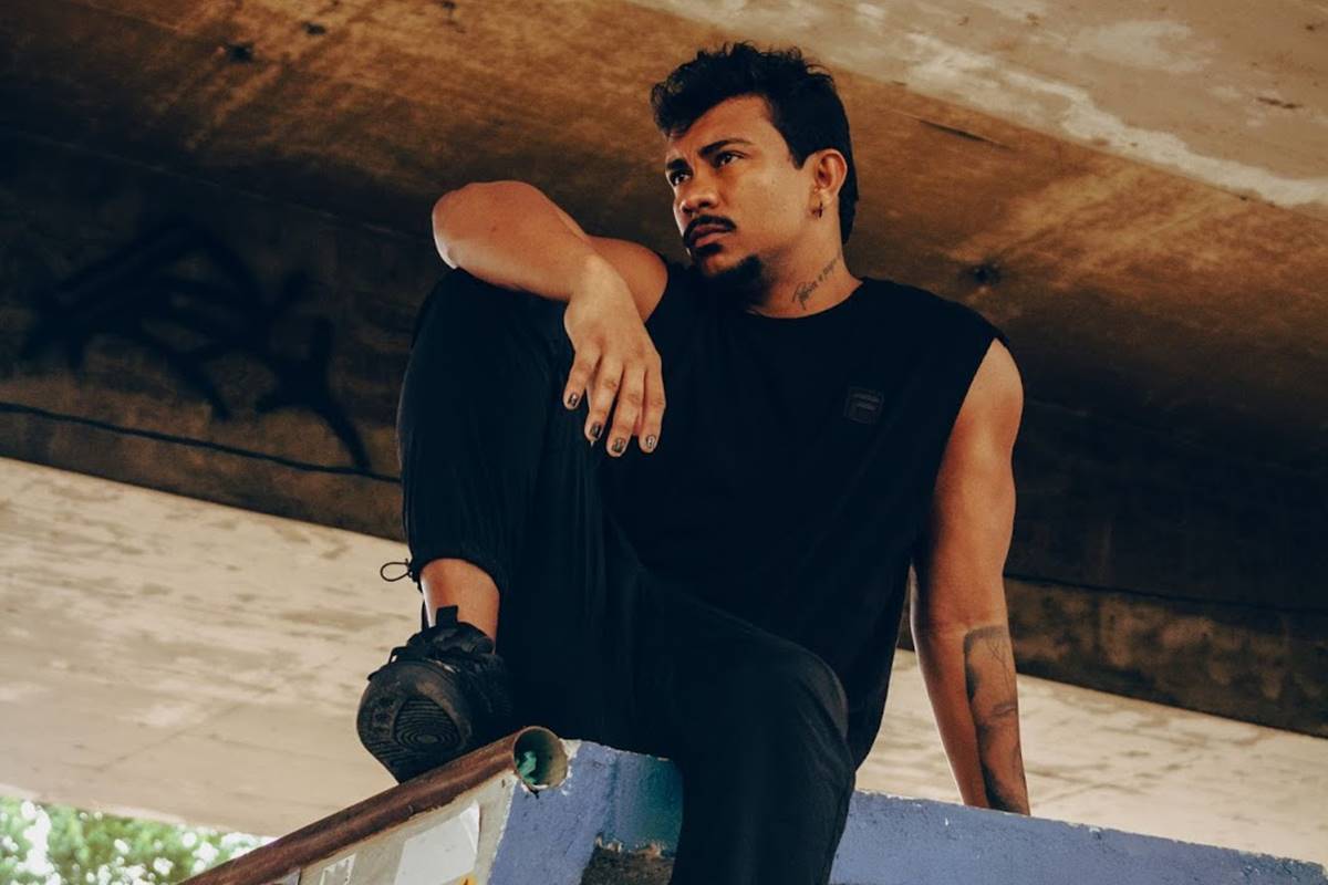 Imagem colorida do rapper Xamã apoiado em mureta, usando preto e olhando para o lado - Metrópoles