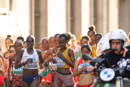Maratonista Rebecca Cheptegei, no centro, de amarelo e listras