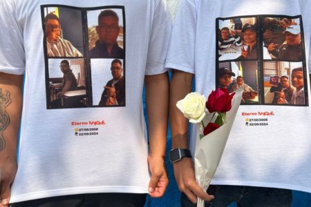 Dois meninos com camisetas pedindo justiça por amigos