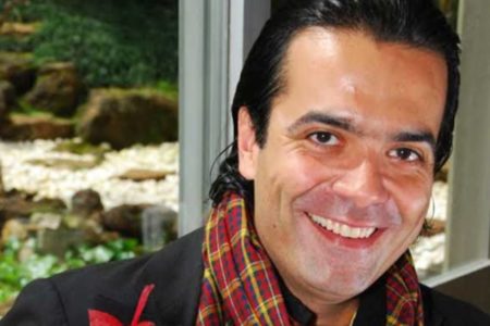 foto colorida de homem branco com cabelos penteados para trás e sorrindo - metrópoles