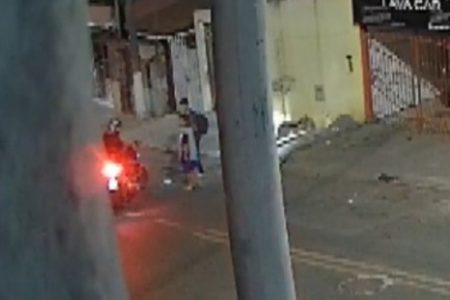Imagem colorida de suspeito em moto abordando dois adolescentes. Metrópoles