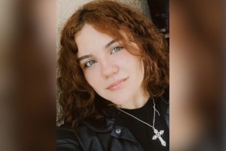 Imagem colorida mostra o rosto de Ianca Victoria de Oliveira Silva, uma mulher branca, de cabelos avermelhados ondulados, vestida de preto