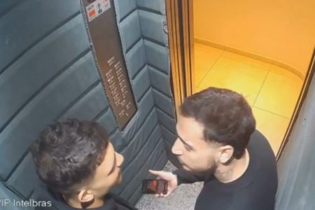 Imagem colorida mostra dois homens conversando dentro de elevador em prédio no litoral de São Paulo, antes de um deles ser morto - Metrópoles