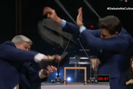 Imagem colorida mostra Datena jogando cadeira em Marçal