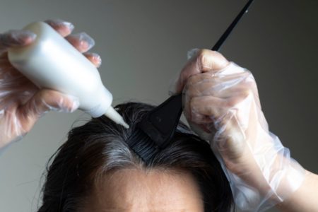 mulher aplicando tinta para cobrir cabelo branco