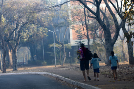 Estudantes vão a escola mesmo com fumaça encobrindo a asa norte por conta dos incendios na floresta nacional