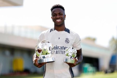 Imagem colorida de Vini Jr com prêmio de melhor jogador da Champions League- Metrópoles