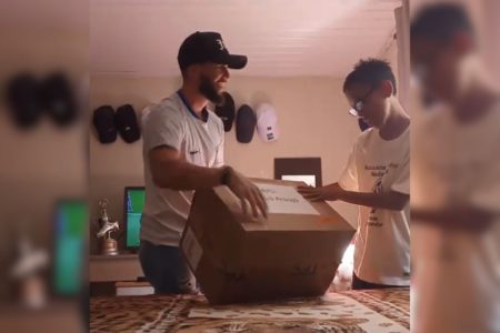 Imagem colorida de menino abrindo caixa de presentes do Neymar - Metrópoles