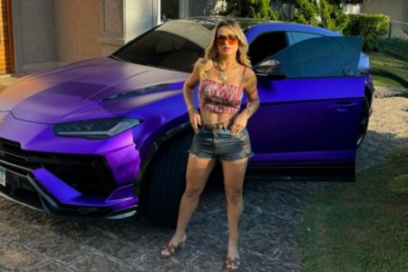 Mulher loira em frente a carro de luxo roxo - Metrópoles