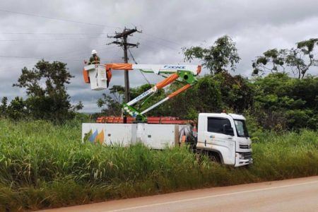 Fotografia colorida mostrando caminhão de empresa de energia com funcionário mexendo em poste-Metrópoles