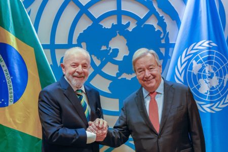 Imagem colorida de Lula e António Guterres dando aperto de mão e sorrindo para a câmera - Metrópoles