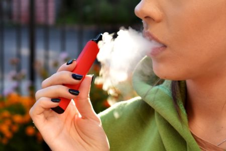 Mulher fuma cigarro eletrônico em local público - Metrópoles