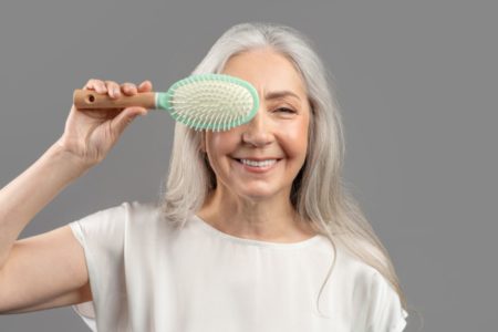 Imagem colorida de mulher idosa com escova na mão