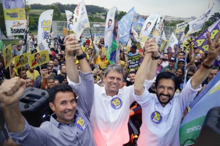 Imagem colorida mostra Coronel Mello Araújo, Tarcísio de Feitas e Ricardo Nunes, de mãos erguidas, no meio de uma multidão de apoiadores - Metrópoles