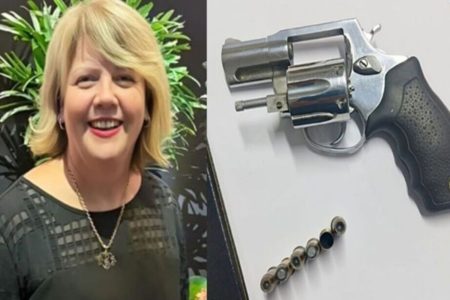 Mulher ao lado de uma arma