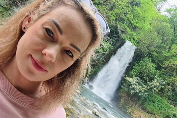 Mulher loira em frente de cachoeira - Metrópoles