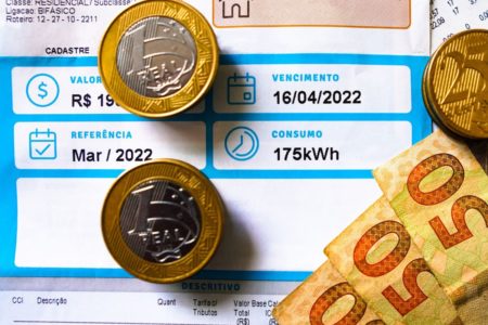 Foto colorida de conta de luz com dinheiro - Metrópoles