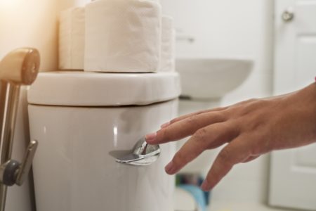 Imagem colorida de pessoa dando descarga em vaso sanitário - Metrópoles