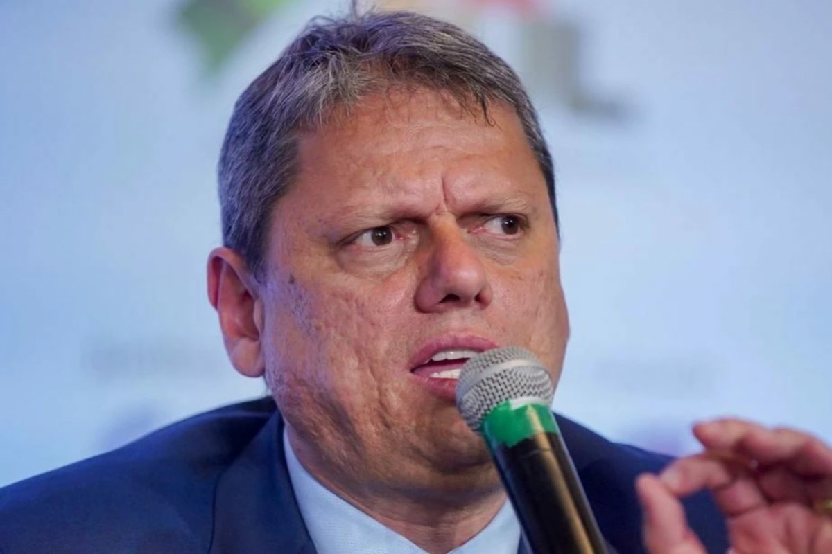 Imagem colorida governador Tarcisio de Freitas, um homem branco de terno falando ao microfone - Metrópoes