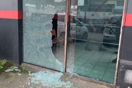 Porta de vidro estilhaçada de base da PM no Guarujá após ataque - Metrópoles