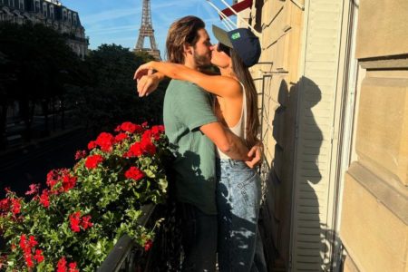 Imagem colorida de Sabrina Sato e Nicolas Prattes em sacada florida, dando beijo - Metrópoles