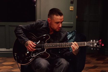 Foto colorida de Liam Payne tocando guitarra - Metrópoles