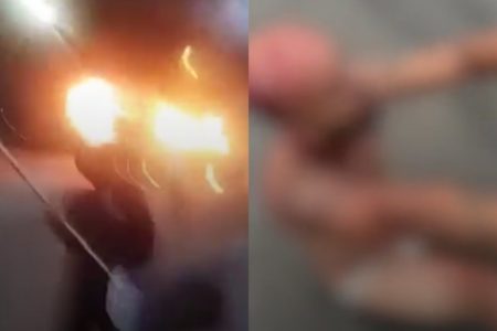 Imagens embaçadas de homem caído em chão suplicando e do lado esquerdo dele veículo em chamas - Metrópoles