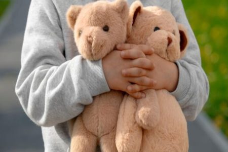 Criança segurando urso