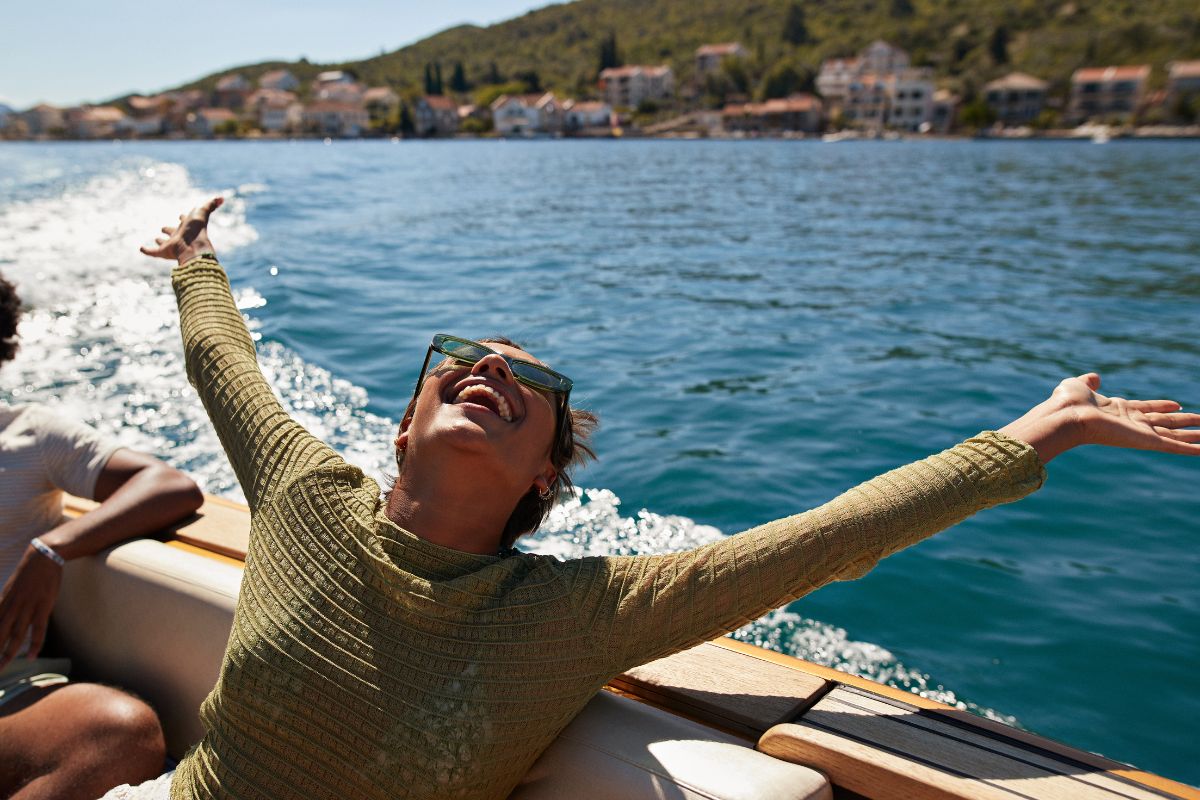 imagem colorida de uma mulher feliz em um passeio de barco