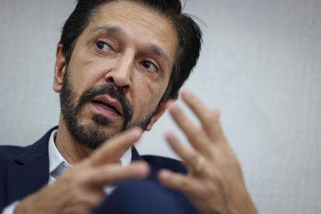 Imagem colorida mostra o prefeito Ricardo Nunes, homem branco, de cabelo e barba pretos, vestindo terno azul e camisa branca, durante entrevista ao Metrópoles em seu gabinete - Metrópoles