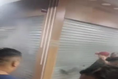 Imagem colorida mostra reprodução de vídeo com comerciantes tentando entrar em box que estava com fumaça saindo da porta - Metrópoles