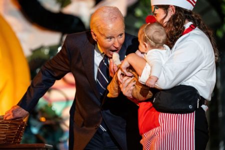 Imagem colorida do Presidente dos Estados Unidos mordendo bebê - Metrópoles