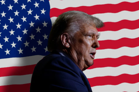Imagem colorida de Donald Trump, com bandeira americana ao fundo -- Metrópoles